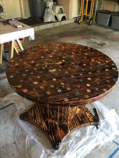 a wooden table sitting on top of a hard wood floor covered in lots of buttons