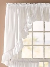 a white window curtain with ruffles hanging from it's rod - end