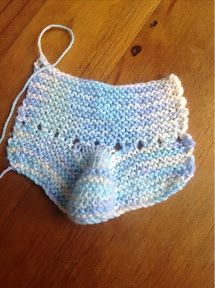 a crocheted blue and white diaper sitting on top of a wooden floor