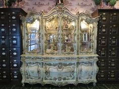 an antique china cabinet with mirrors on top