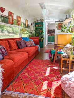 a living room with red couches and rugs on the wooden floored floor