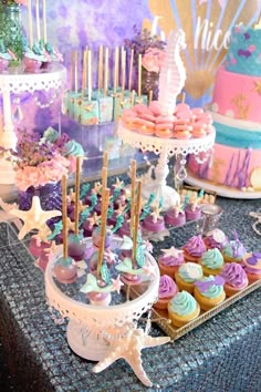 a table topped with lots of cupcakes and cakes