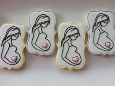 three decorated cookies in the shape of pregnant women