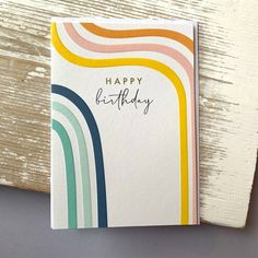 a card with the words happy birthday written on it and rainbows painted on it