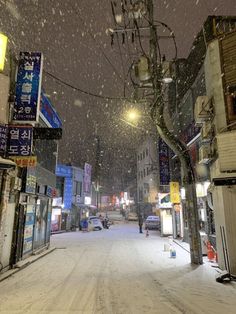 a snow covered street with people walking on it