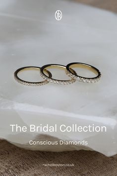 two wedding rings sitting on top of a white marble slab with the words, the bridal collection conscious diamonds