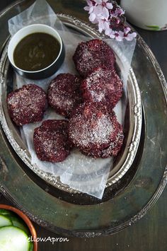 powdered sugar covered pastries on a plate with dipping sauce