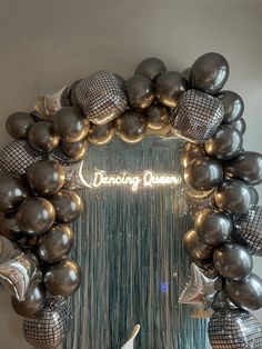 a dancing queen sign surrounded by balloons and streamers in the shape of a wreath