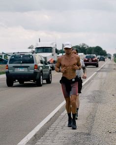 a shirtless man running down the road