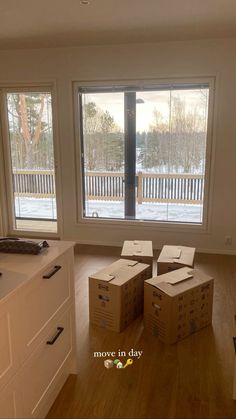 boxes are stacked on top of each other in the middle of a room with large windows