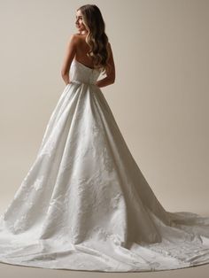 a woman in a white wedding dress posing for the camera with her hands on her hips