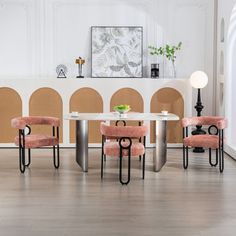 a white table with four pink chairs around it