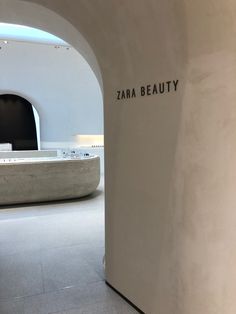 the entrance to an art gallery with white walls and black lettering that reads zara beauty