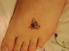 a small bee tattoo on the foot