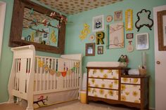 a baby's room with a crib, dresser and mirror on the wall