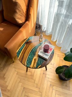 a coffee table sitting on top of a hard wood floor next to a chair and window