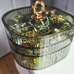 a stack of jewelry sitting on top of a white counter next to a mirror door