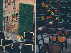 chairs and tables in front of a brick wall with flowers on the top, and an outdoor seating area