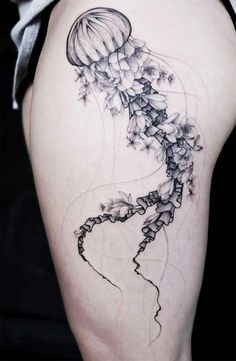 a woman's thigh with a jellyfish tattoo on it