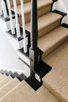 an image of a stair case with black and white railings on the bottom floor