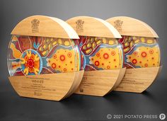 three wooden plaques with colorful designs on them