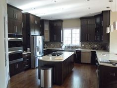 a large kitchen with dark wood cabinets and stainless steel appliances