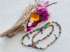 "This cheerful long floral stretchy necklace features 86 glass beads, most of them millefiori, and some small gemstones like, turquoise, jade, agate, cat's eye, howlite, serpentine, 52 silver tone bead dividers and 8 charms, including a lady bug silver charm.  It is 28 inches long and weights  2.5oz. Millefiori  ( Italian) is a glasswork technique which produces distinctive decorative patterns on glassware.  The term millefiori is a combination of the Italian words \"mille' (thousand) and \"fior Bohemian Glass Beaded Necklace With Natural Stones, Adjustable Multicolor Spiritual Long Necklace, Bohemian Multicolor Crystal Necklace With 108 Beads, Hand-strung Glass Bohemian Beaded Necklaces, Hand-strung Bohemian Glass Beaded Necklaces, Bohemian Hand-strung Glass Beaded Necklaces, Adjustable Spiritual Long Necklace With Colorful Beads, Multicolor Bohemian Hand-strung Crystal Necklaces, Bohemian Glass Necklaces For Festivals