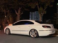 a white car is parked on the street at night