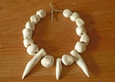 a bracelet made out of white beads with two spikes on each side and one in the middle