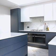 a kitchen with blue cabinets and white counter tops is seen in this image from the front view