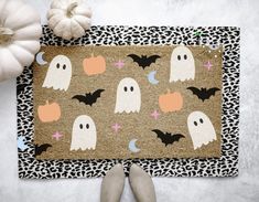 a halloween door mat with ghost and pumpkins on it