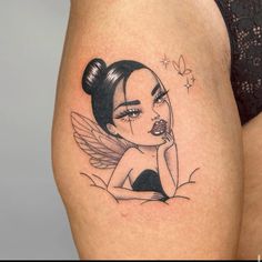 a woman's thigh with a cartoon character tattoo on her leg and an earring