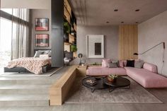 a living room filled with furniture and a large window next to a stair leading up to a bed