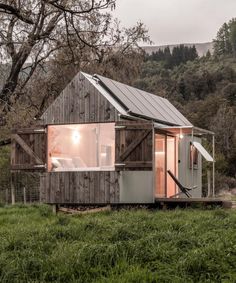 a small wooden cabin in the middle of a field