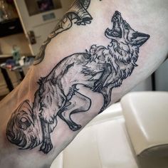 a man's leg with a wolf tattoo on it