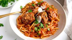 spaghetti with meatballs and sauce in a white bowl