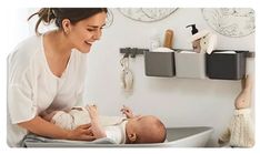 a woman is holding her baby in the bathtub