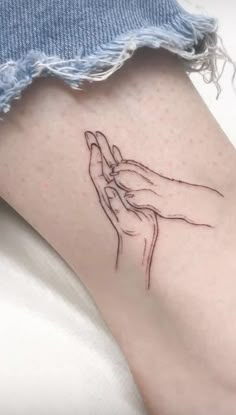 a woman's leg with a tattoo on it that has a hand holding something