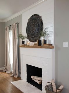 a living room with a white fireplace and wooden floors