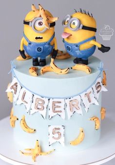 two minion figures are on top of a birthday cake