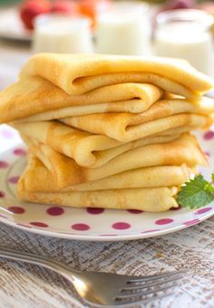 a stack of pancakes sitting on top of a plate next to a glass of milk