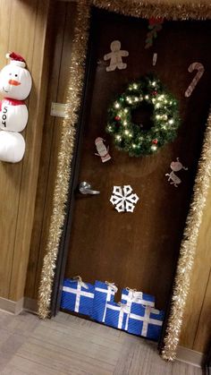 a door decorated with christmas decorations and snowmen