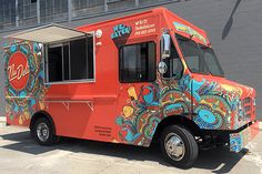 an orange food truck parked in front of a building