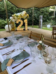 the table is set for an event with white and gold decorations