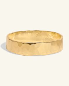 a gold wedding band with an irregular design on the outside, and a thin edge