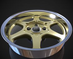 an image of a wheel that is shiny gold on black background with reflection in it