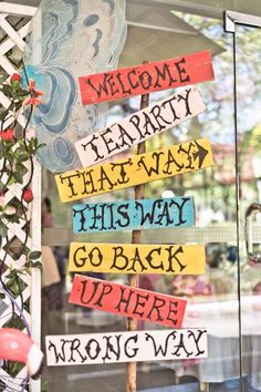 a welcome sign in front of a glass door that says, welcome party that way this way go back up here wrong way