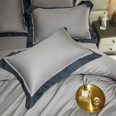 a close up of a bed with grey and blue sheets