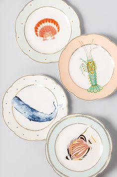 three plates with different designs on them, one has a fish and the other has a seahorse