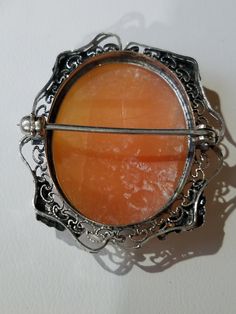 "This Victorian Sterling Silver Cameo Brooch features a Pinkish Shell in an oval shaped octagonal frame, hand carved with a Lady Facing Right. The base metal has intricate Silver metal work with elegant flowers on both sides and bottom side frames. The brooch has an early safety catch and secure. It has the hallmark \"STERLING\" across the inner rim. When you put the brooch up to the light it is transparent. This brooch makes a excellent Christmas Gift or Mother's Day Gift. Will arrive in a gift Ornate Oval Engraved Brooches, Victorian Oval Filigree Brooches, Antique Oval Engraved Brooches, Ornate Oval Brooch For Formal Occasions, Ornate Oval Filigree Brooches, Ornate Oval Brooches For Formal Occasions, Antique Oval Cabochon Brooches, Oval Brooch With Intricate Design As A Gift, Intricate Oval Brooch As Gift